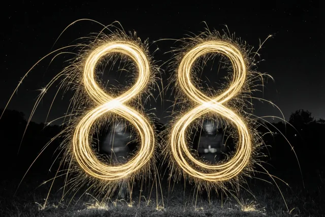 Gouden vonkensporen vormen 88 boven gras onder een sterrenhemel, met vage silhouetten van mensen binnen de lussen.