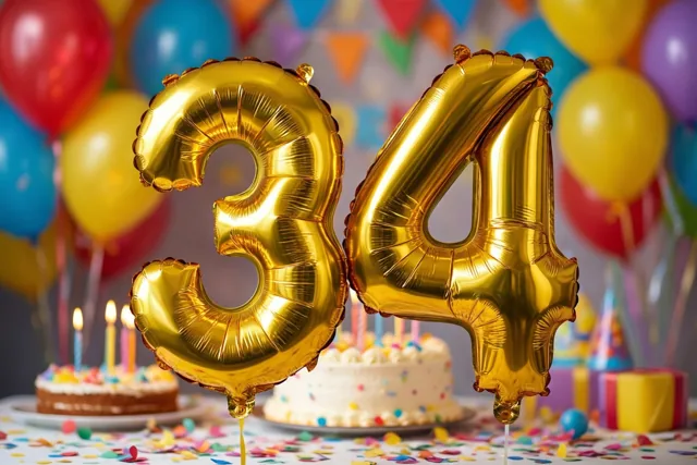 Grote gouden folieballonnen vormen 34 boven een feesttafel met gekleurde confetti en verjaardagstaarten, met kleurrijke ballonnen en feestversiering op de achtergrond.