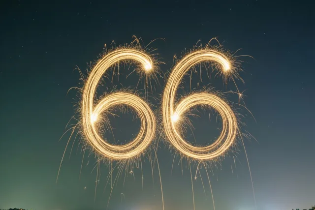 Gouden lichtsporen van sterretjes vormen het getal 66 tegen een donkerblauwe nachthemel met zwakke sterren.