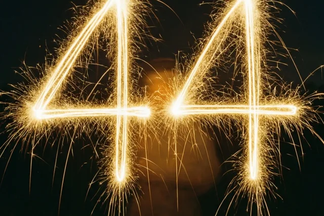 Gouden lichtsporen van sterretjes vormen 44 tegen een donkere nachthemel.