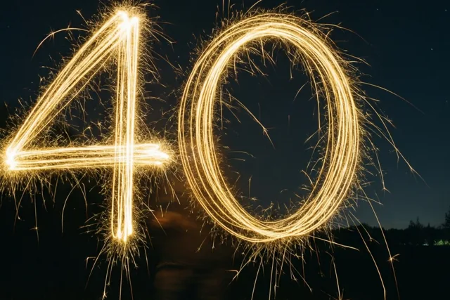Gouden lichtsporen schrijven het getal 40 tegen een donkere hemel met zichtbare sterren.
