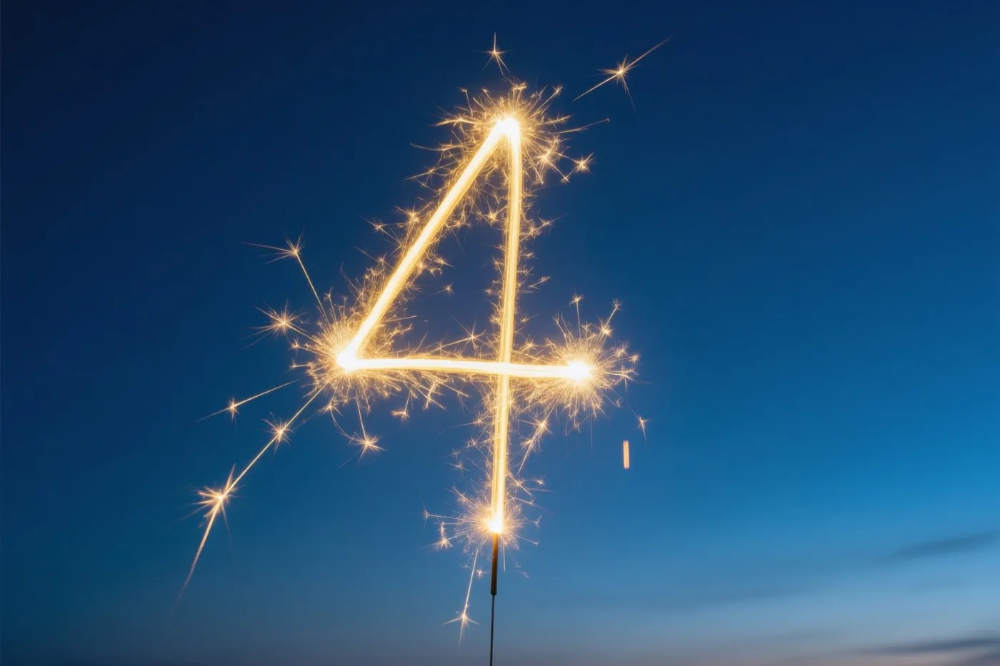 Gouden lichtsporen en vonken vormen het cijfer 4 tegen een diepblauwe nachthemel.