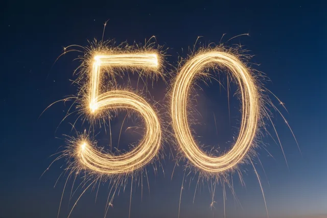 Gouden lichtsporen van sterretjes vormen 50 tegen een diepblauwe nachtlucht.