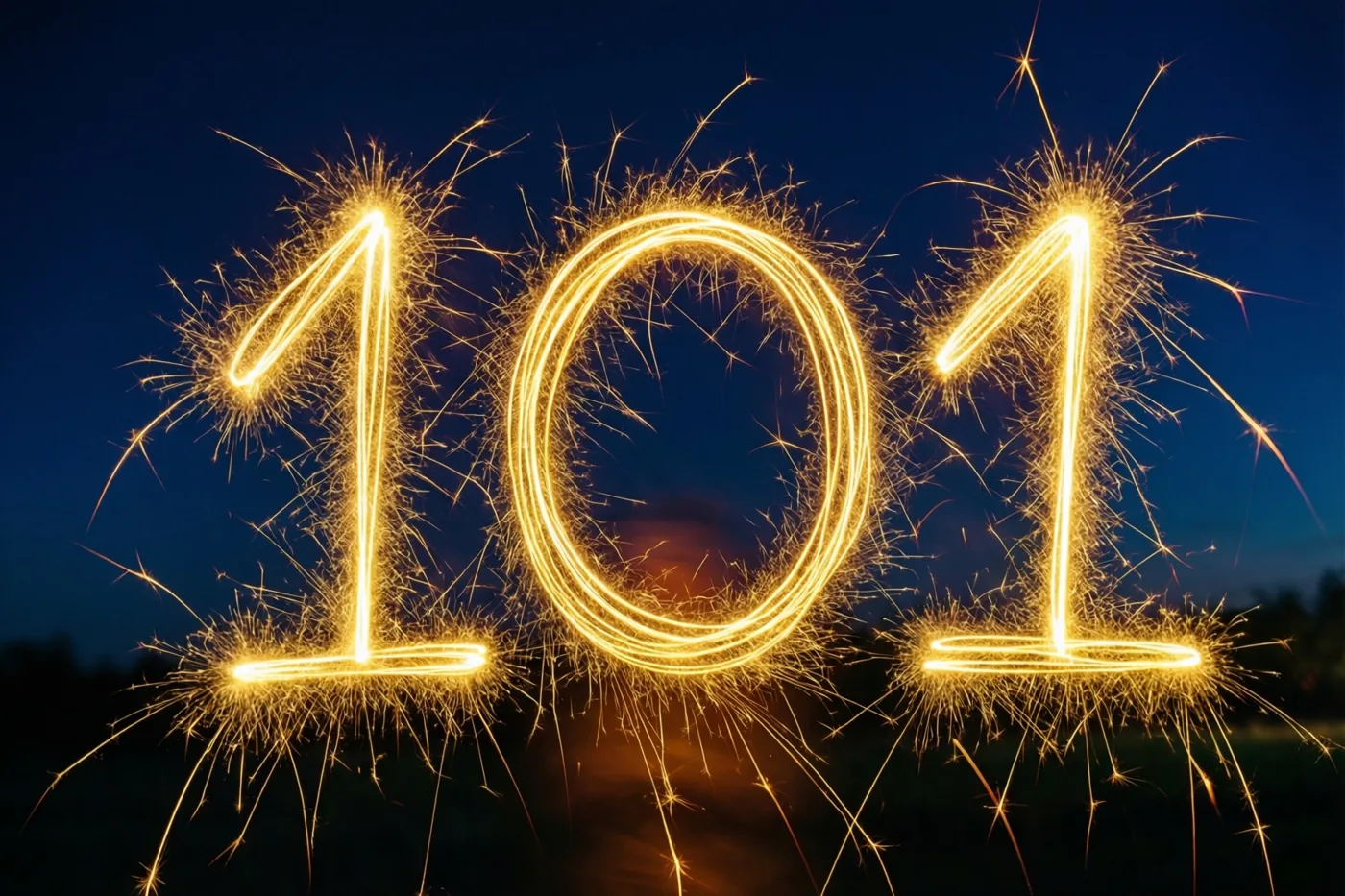 Gouden lichtsporen van sterretjes vormen 101 tegen een diepblauwe nachthemel.
