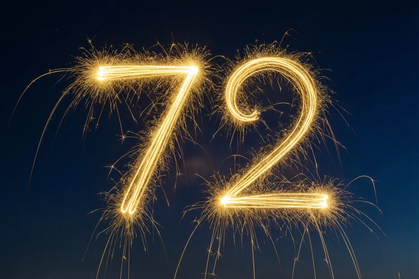 Gouden vonkensporen vormen 72 tegen een diepblauwe nachthemel.