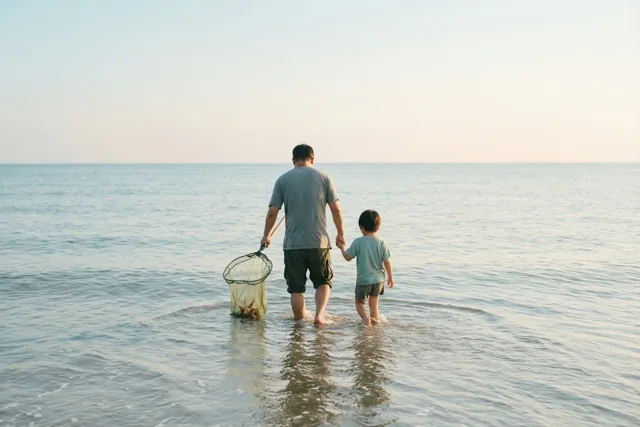 Papa's hand in het zeewater