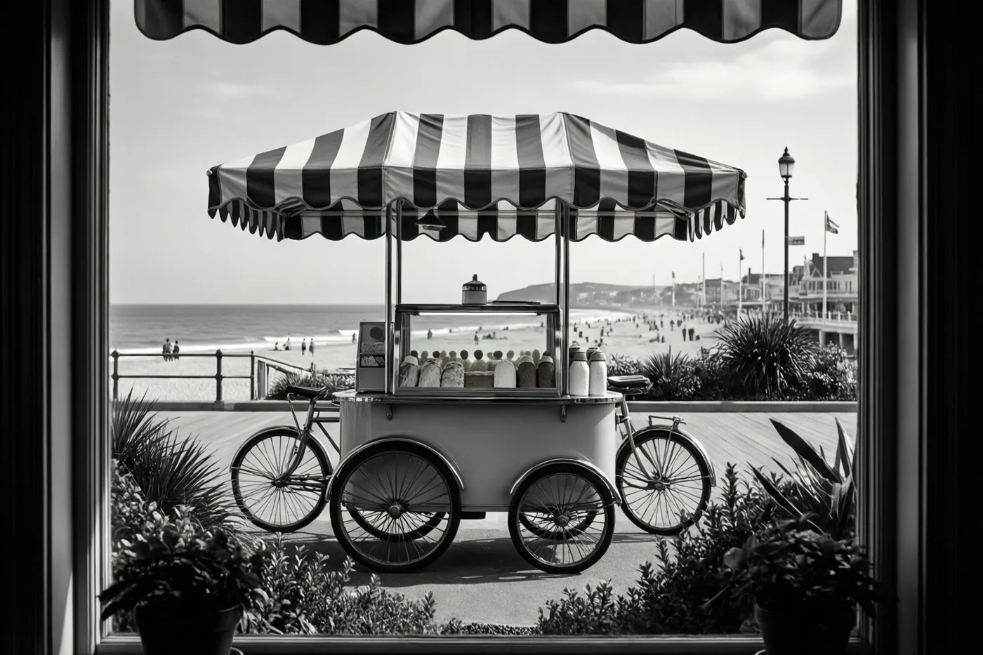 Een zwart-witbeeld toont door een raam een vintage-ijskar met een gestreepte luifel op een wandelpromenade aan zee.