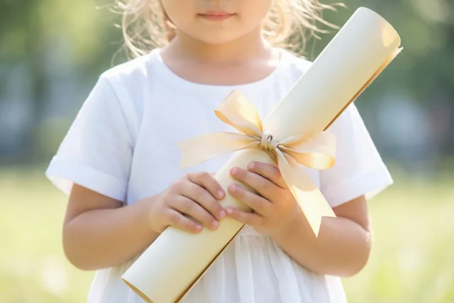 Kleine handen met een gouden strik