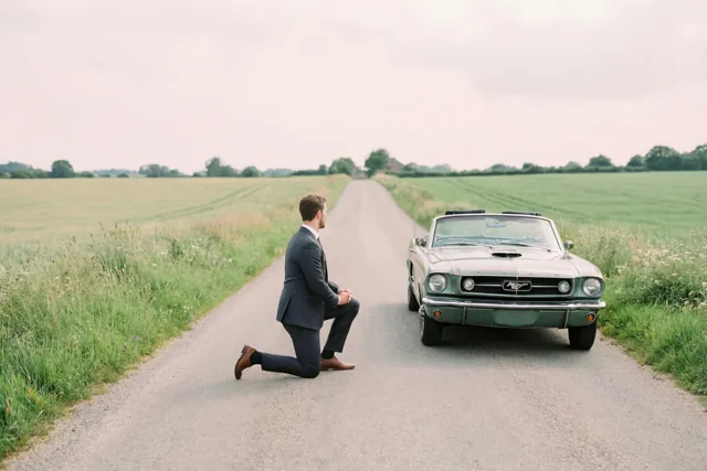 Op de knieën naast de oldtimer
