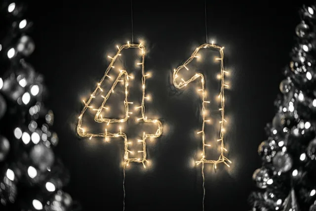 Warme lichtslingers vormen 41 tegen een donkere muur, met aan beide kanten onscherpe fonkelende lichtjes.