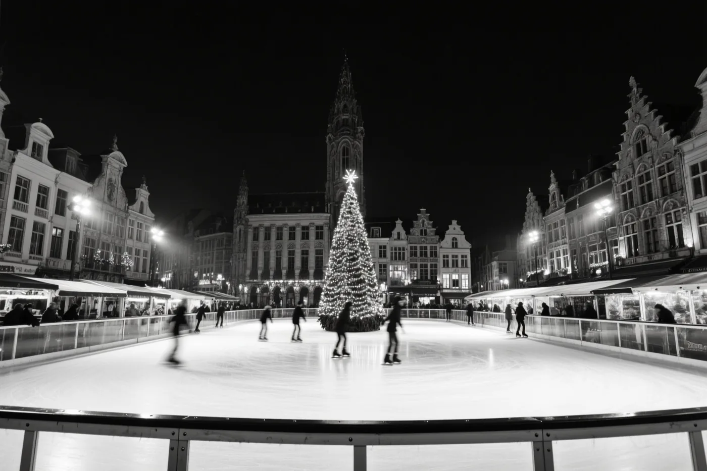 Een zwart-witfoto toont schaatsers op een ijsbaan op een Belgisch marktplein bij nacht, met een fel verlichte kerstboom in het midden en historische gebouwen eromheen.