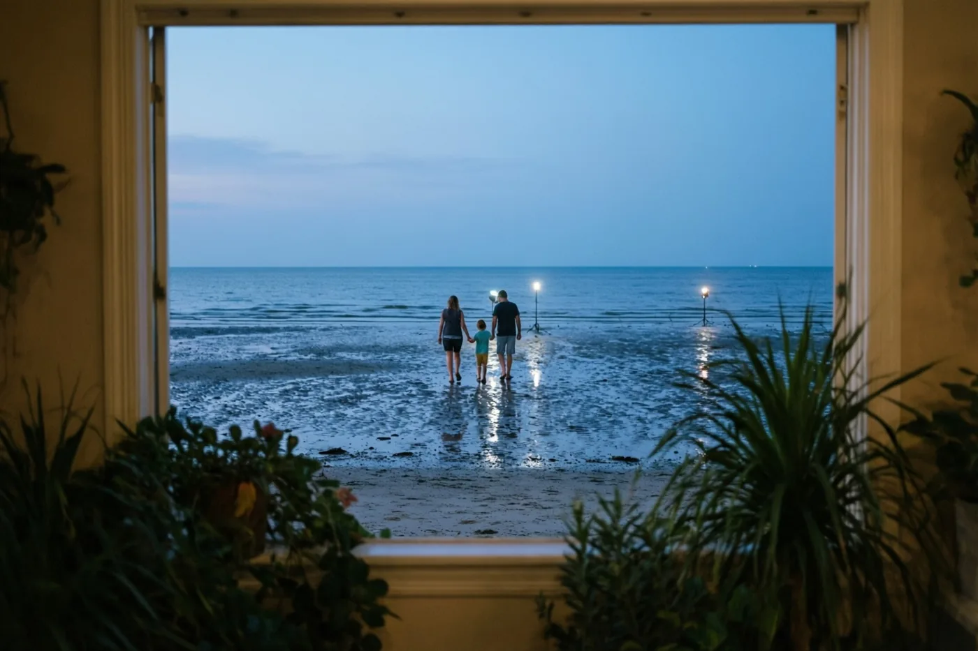 Door een open raam is een gezin van drie van achteren te zien op een nat strand bij eb, met blauwe schemertinten en verre lichtjes die op het water weerspiegelen.
