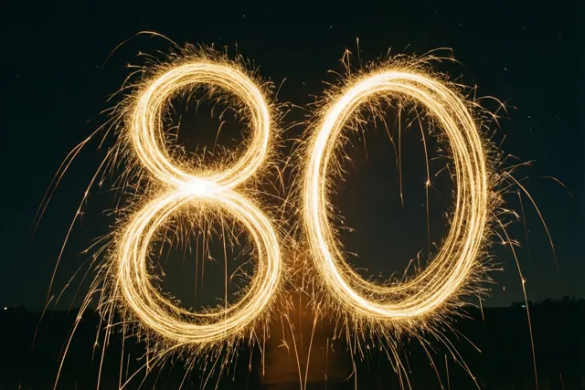 Gouden lichtsporen van sterretjes vormen 80 tegen een donkere nachthemel.