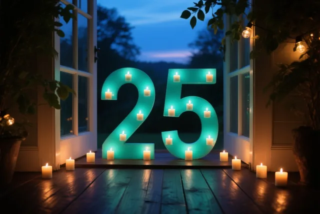 Brandende theelichtjes vormen 25 op een donkere houten vloer, met door een open deur een blauwe avondlucht en rondom groen en lichtslingers.