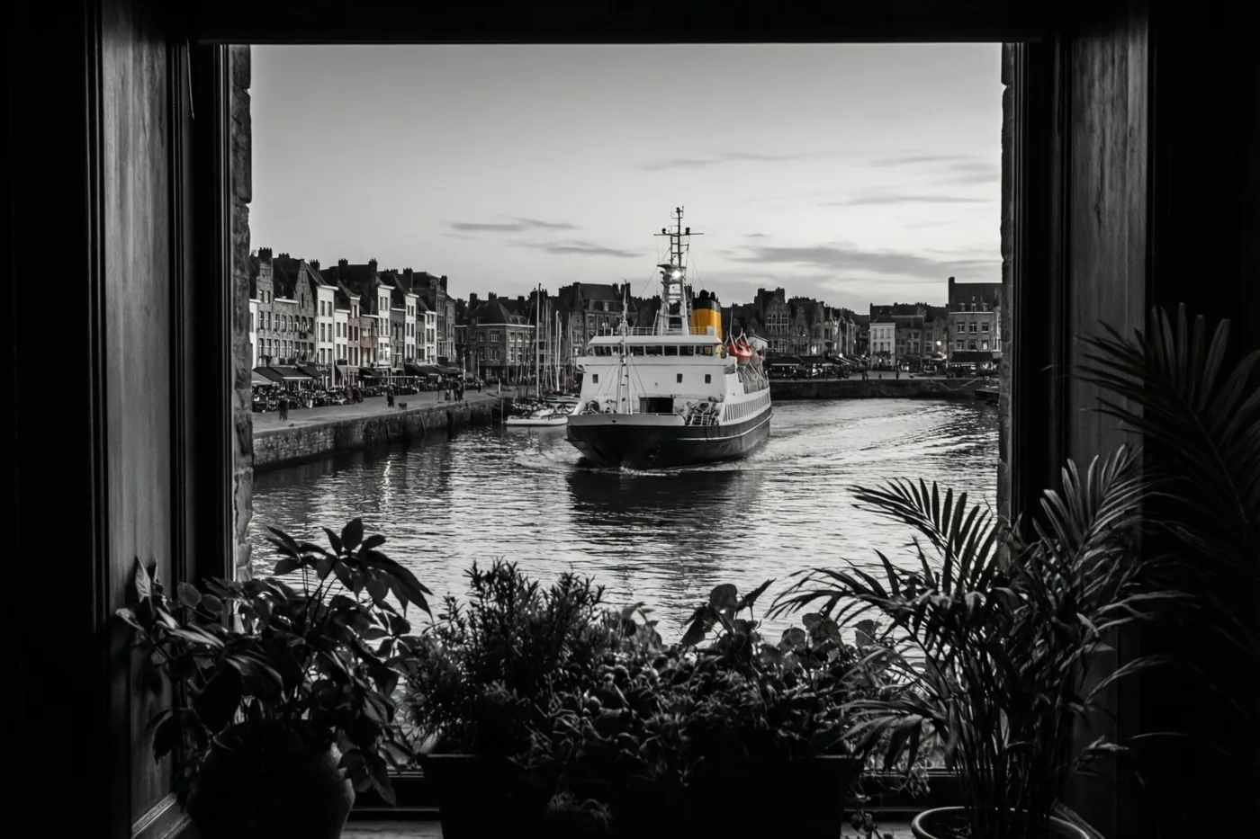 Een zwart-witfoto toont door een raam met potplanten een vertrekkende veerboot bij een haven, met gebouwen langs het water onder een bewolkte avondlucht.