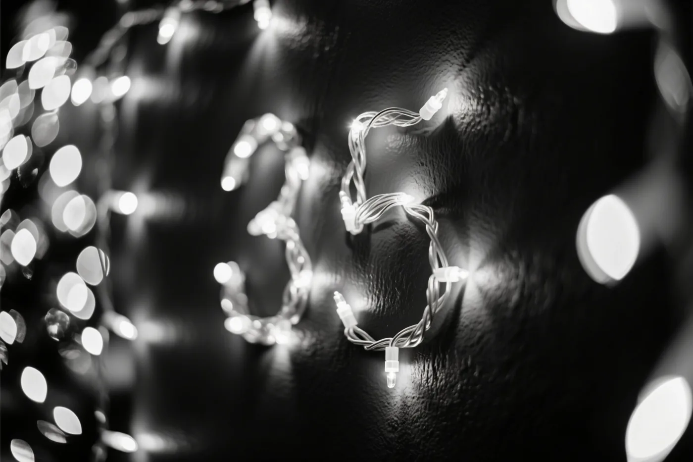 Lichtjes vormen het getal 35 op een donkere muur met structuur, met wazige feestlichtjes op de achtergrond.
