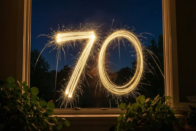 Door een raam met kamerplanten zijn gouden lichtsporen van sterretjes in de vorm van 70 tegen de donkere nachthemel te zien.