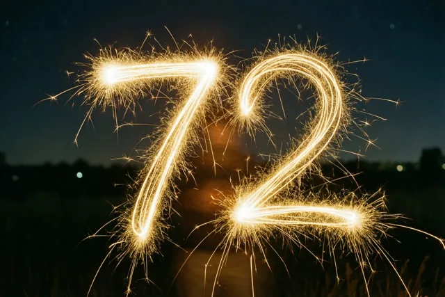 Gouden vonkensporen vormen 72 in de nacht, met onscherp gras en lichtjes in de verte.