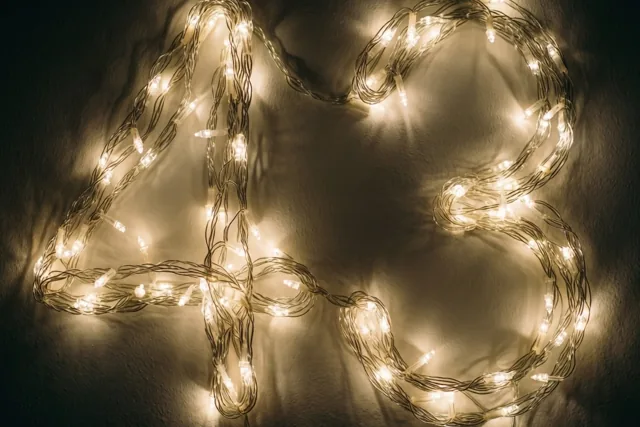 Het getal 43 is gevormd uit warm gloeiende lichtslingers tegen een donkere muur, met zacht vervaagde lichteffecten.
