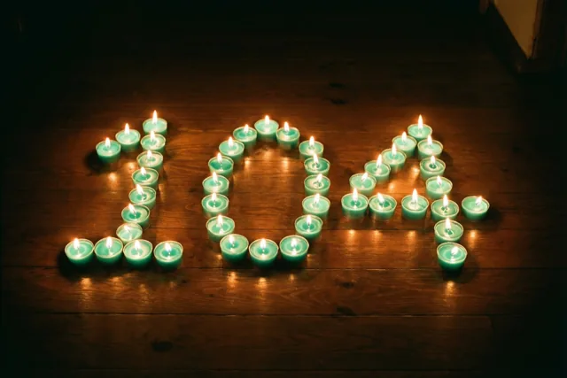 Theelichtjes vormen 104 en verlichten een donkere houten vloer met een zachte gloed.