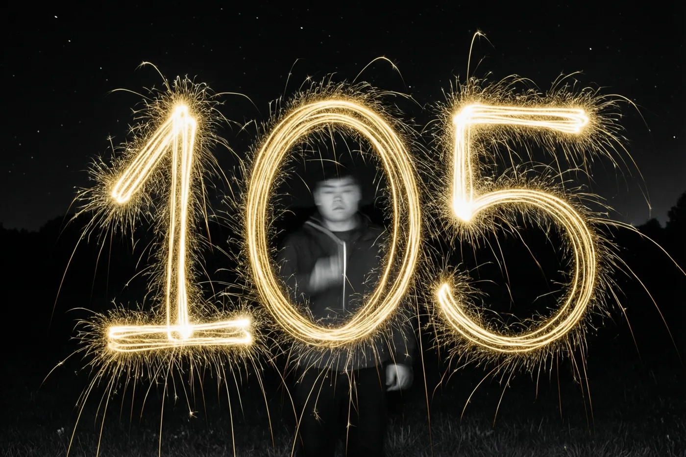 Gouden lichtsporen van sterretjes schrijven 105 tegen een donkere hemel met sterren.