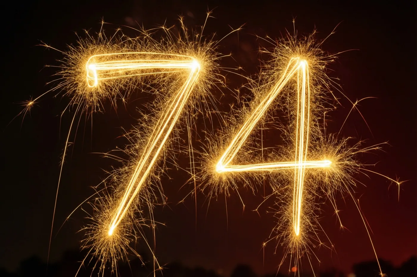 Het getal 74 is gevormd door gouden lichtsporen van sterretjes tegen een donkere nachthemel, met warme goudgele en oranje tinten.
