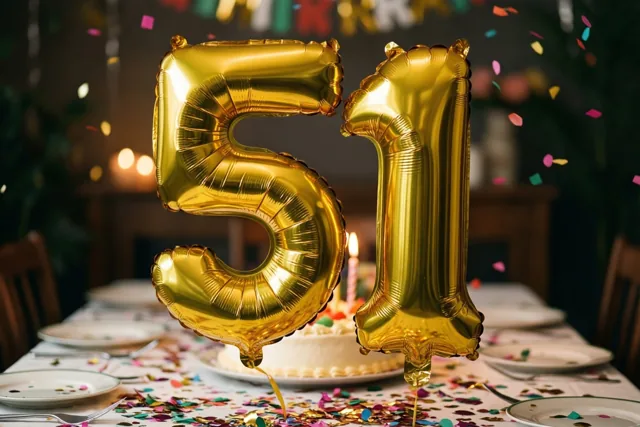 Grote glanzende gouden folieballonnen 5 en 1 zweven boven een feesttafel met kleurrijke confetti, met een taart en kaarsen op de achtergrond.