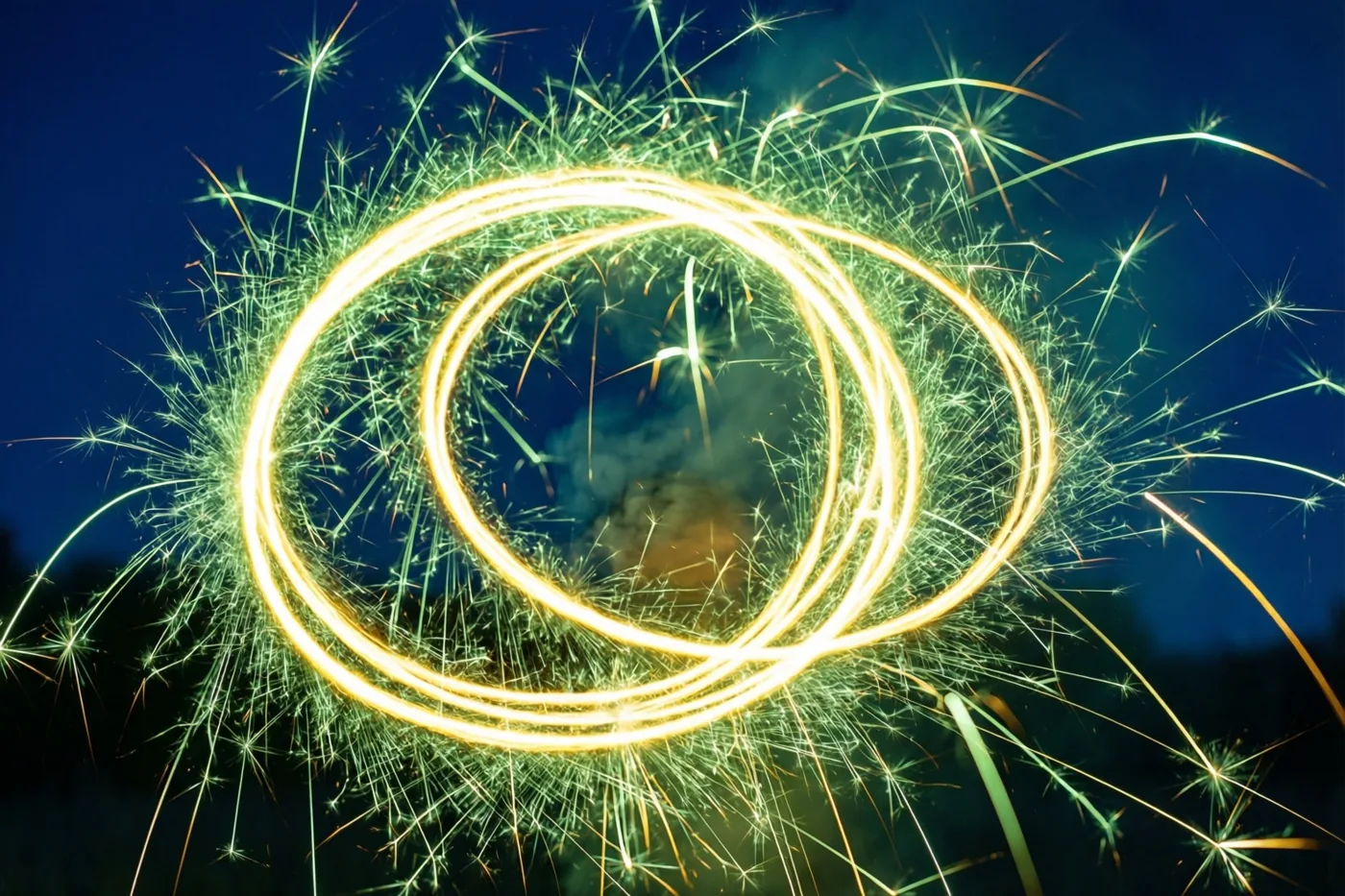 Gouden lichtsporen van draaiende sterretjes vormen lussen met heldere vonken die naar buiten stralen tegen een diepblauwe nachthemel.