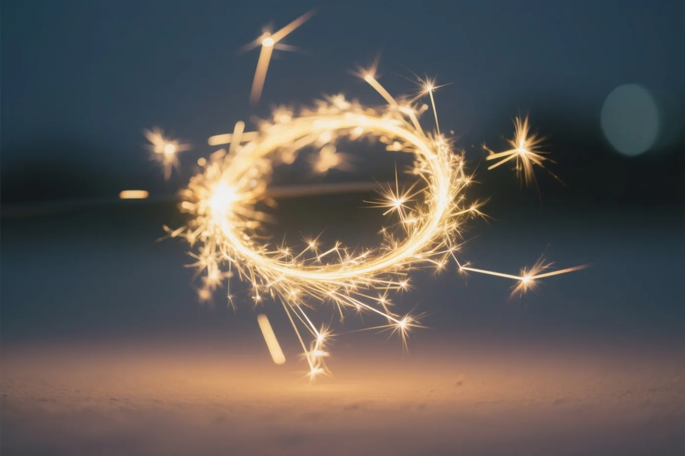 Gouden lichtsporen van sterretjes draaien in lussen tegen een donkere nachtlucht en verlichten het zand eronder.