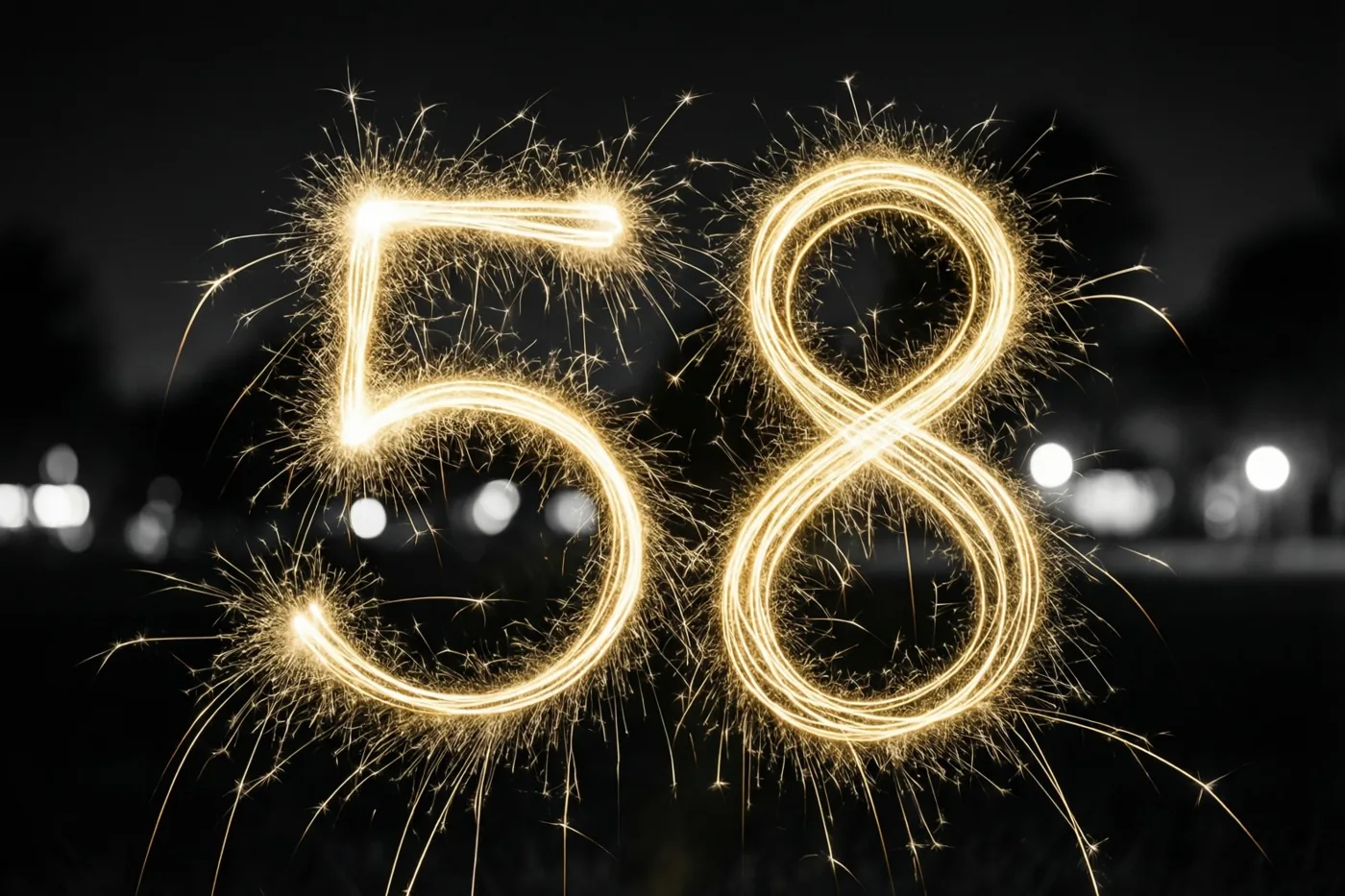 Gouden lichtsporen van sterretjes vormen 58 tegen een donkere nachthemel, met onscherpe stadslichten op de achtergrond.
