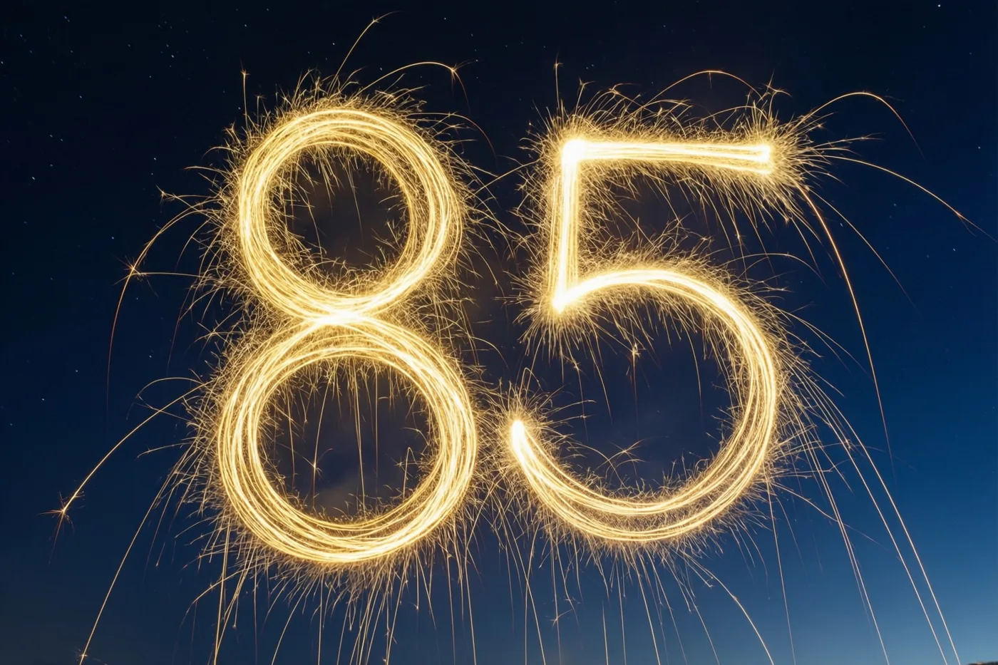 Gouden lichtsporen van sterretjes vormen 85 tegen een donkere nachthemel met zichtbare sterren.