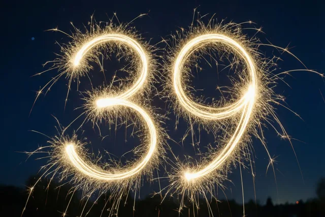 Gouden lichtsporen van sterretjes vormen 39 tegen een donkerblauwe nachthemel.