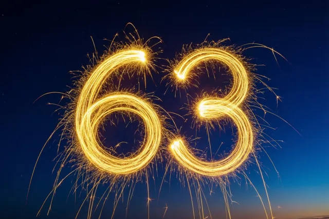 Gouden vonkensporen vormen 63 tegen een donkere nachthemel die bij de horizon in blauw overgaat.