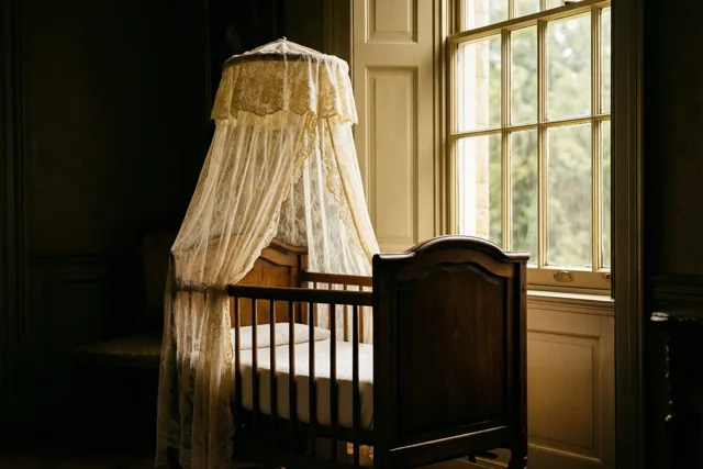 Een oude houten wieg met een kanten hemel staat naast een hoog raam in een schemerige kamer met zacht daglicht en warme tinten.