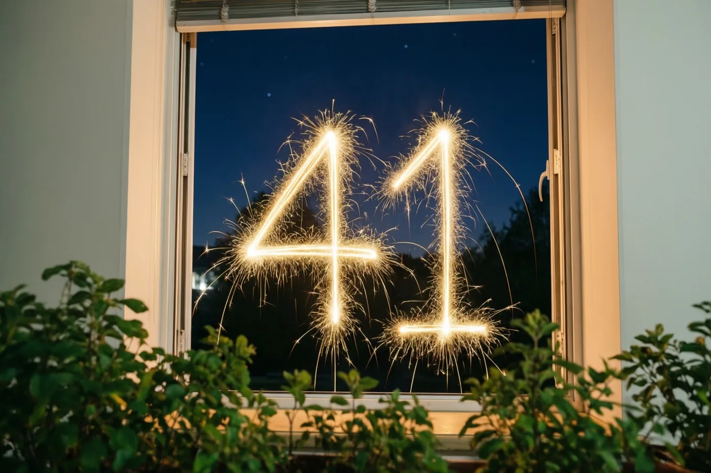Gouden vonkensporen vormen 41 op een raam bij nacht, omlijst door het raamkozijn en kamerplanten tegen een diepblauwe lucht.